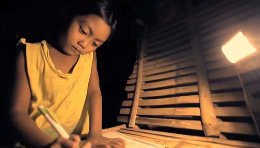 An indigenous Filipino child studies by a solar lamp in Oriental Mindoro
